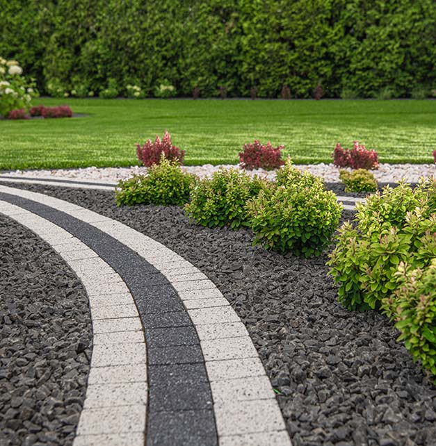 A serene garden featuring a winding pathway surrounded by lush green shrubs